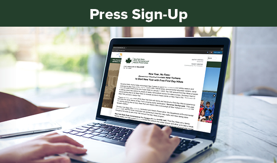 Press Release Sign-Up. A stock image of a laptop on a desk. The laptop has the homepage of parks.ny.gov open in the background. In the foreground there is a press release open. Most of the text is illegible, however the headline can be seen clearly. It reads, "Governor Hochul Celebrates New York State Parks and Historic Sites Centennial."